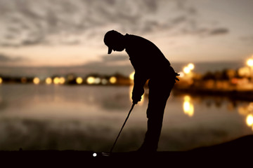 silhouette of golfers hit sweeping and keep golf course in the sunset