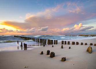 beach and offshore breakwaters during a beautiful sunset, baltic sea
