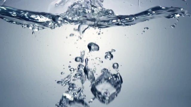 Slo-motion cubes falling through water. 120 fps.