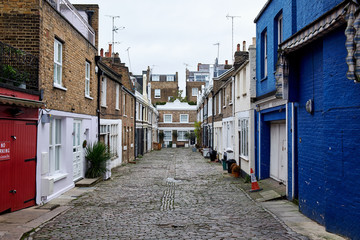 Denbigh Close a small cobblestone covered alley with low apartment buildings seen from Portobello Road