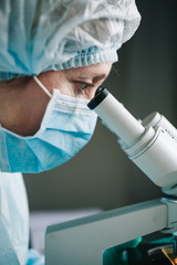 Close up view of scientist eye looking at microscope.