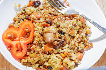 Ready pilaf in a dish with a fork.