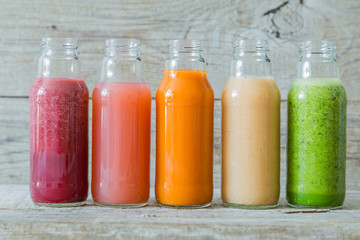 Selection of colourful smoothies on rustic wood background