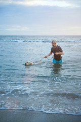 Man with labrador dog in water