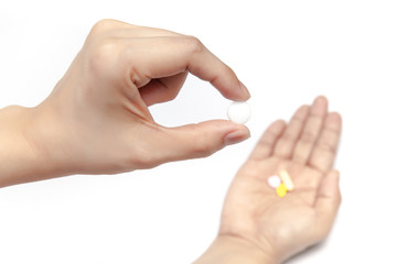 Pick one pill from the medicines in the hand on white background isolated