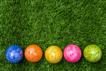 Bunte Ostereier in einer Reihe stehen auf einer Wiese