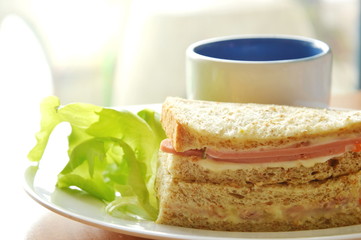 pork bologna whole wheat sandwich with fresh green oak and coffee on dish