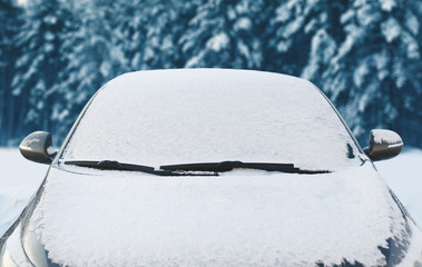 Frozen car covered snow at winter day, view front window windshi