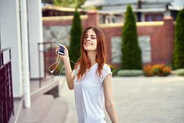 happy woman walking around the city, listening to music, phone, headphones