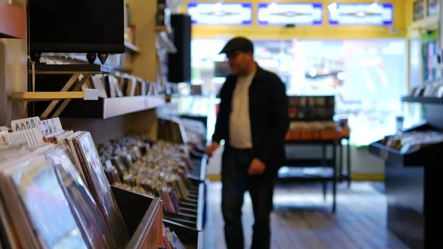 Man with black shirt browsing records in the vinyl record store