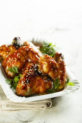 Chicken wings in maple syrup glaze with sesame seeds