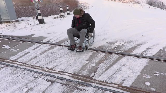 Disabled man on wheelchair on railway crossing