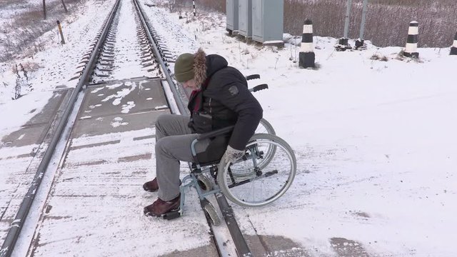 Disabled man on wheelchair try to cross railway crossing