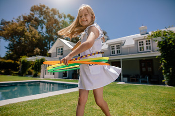 Smiling girl playing with hula hoop outdoors © Jacob Lund