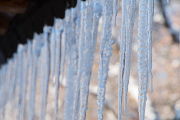 Snowy ice Icicles hanging on a roof house