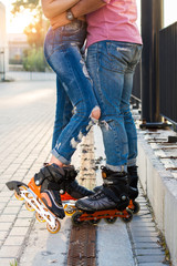 Legs wearing inline skates. Couple in jeans. Fashion and sport.