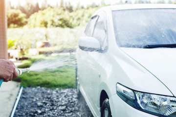 Soft focus hand holding car wash hose