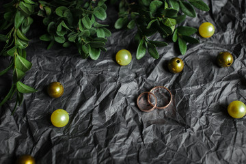 Wedding. Wedding rings on kraft Bumacov with green leafy plants.