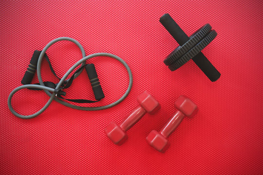 Gym Equipment On Red Mat Background, Top View