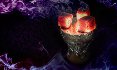 Bright red hot hookah coals on an earthenware shisha bowl with foil. Smoke around on a black background. © bestforbest