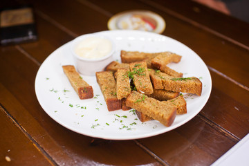 Plate with fried croutons with herbs and sauce