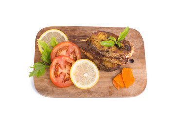 Fried fish in a plate with ingredients