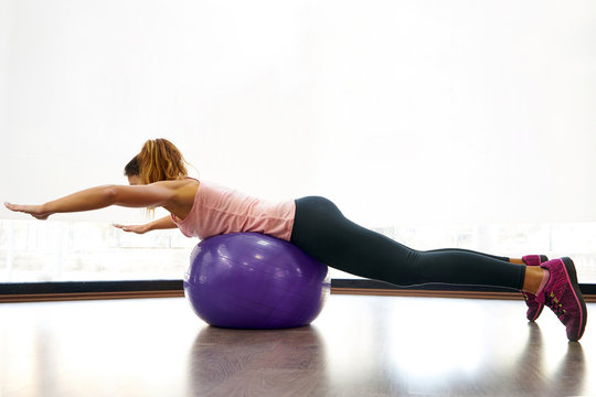 Athletic woman exercising with ball in gym