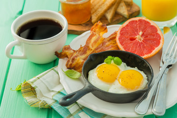 Summer breakfast - eggs, bacon, toast, jam, coffee, juice