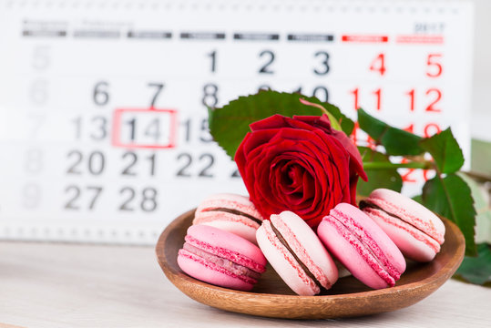 Concept Valentine's Day, red rose and pastries on background on