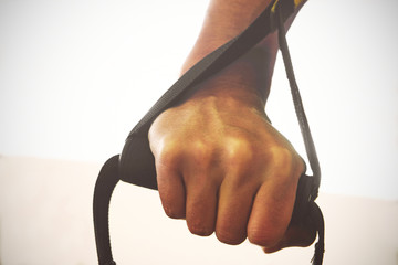 TRX. Male hands with fitness TRX straps in gym.