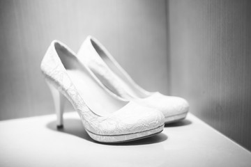 White high heeled shoes for female and bride on the shelf under light