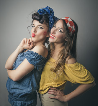Two happy young female friends in retro clothing
