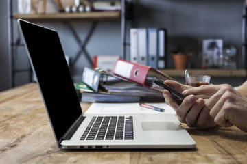 Man working at his home with laptop, moblie phone and documents