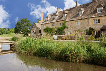 Row of stone cottages on Malthouse Lane next to the River Eyre, Lower Slaughter, England