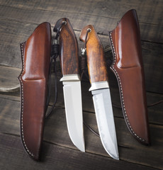 hunting knife handmade on a brown wooden background