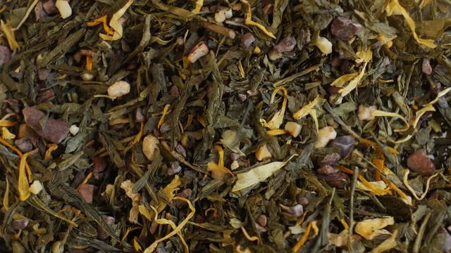 Green tea flavored with chocolate and almond pieces, close up. Loopable rotation. In front of the camera rotates plate with green tea.