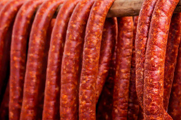 Row of Smoked Sausages hanging out to dry on a wooden pole