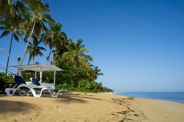 Beautiful tropical white sandy beach with sun loungeres   in Las