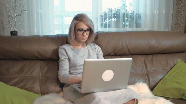 Young woman working at her laptop computer and is shocked