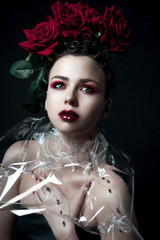 Beauty Fashion Model Woman face. Portrait with Red Rose flowers. Red Lips and Nails. Beautiful Brunette Woman with Luxury Makeup, perfect skin. Valentine.