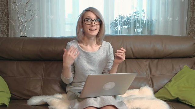 Young businesswoman with laptop computer talking to the camera