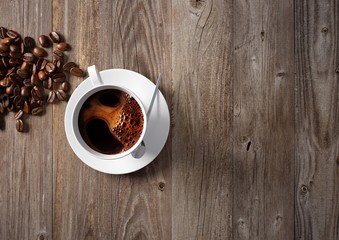 Coffee cup with roasted beans on rustic table