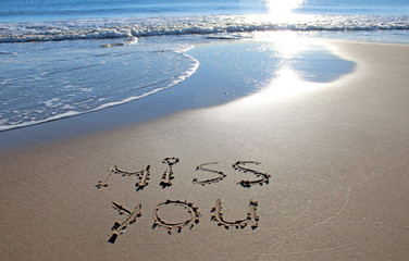 Sunset on the beach with Miss You sign