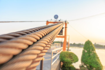 Closeup of wire or sling cable holding Suspension bridge across a river.Selective Focus on Center.