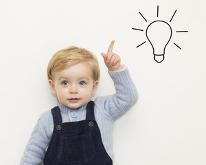 Cheerful smiling child pointing up on white background