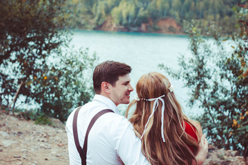 Fototapeta premium couple sitting by the lake on a bench