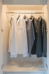 black and white color tone clothes hanging on rail