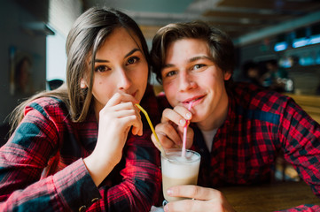 Group of young friends hanging out at a coffee shop. Young men and women meeting in a cafe having fun and drinking coffee. Lifestyle, friendship and urban life concepts.