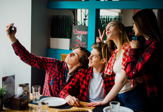 Group Of Young Friends Hanging Out At A Coffee Shop. Young Men And Women Meeting In A Cafe Having Fun And Drinking Coffee. Lifestyle, Friendship And Urban Life Concepts.