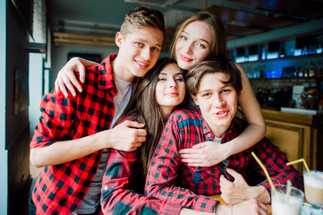 Group of young friends hanging out at a coffee shop. Young men and women meeting in a cafe having fun and drinking coffee. Lifestyle, friendship and urban life concepts.